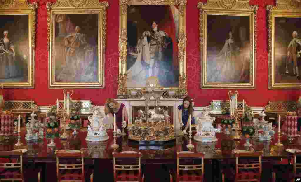 Palace staff arrange the dining table, a copy of Queen Victoria&#39;s reign dessert table, on display, as part of an exhibition at Buckingham Palace, in London.