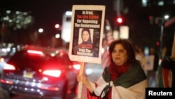 Iranian expatriate Roxanne Ganji holds a sign at a protest in Los Angeles, Jan. 3, 2018.