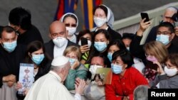 Paus Fransiskus menyapa orang-orang saat ia tiba di halaman San Damaso untuk audiensi umum mingguan di Vatikan, 30 September 2020. (Foto: REUTERS/Yara Nardi)