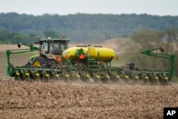 FILE - A farmer plants soybeans in a field in Springfield, Neb., May 23, 2019.