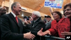 美国会参议员候选人罗伊·莫尔在阿拉巴马州举行的一个竞选集会上与支持者握手。（2017年12月11日）