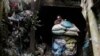 A Filipino miner pushes a cart containing sacks of mineral muck ore in the Compostela Valley, southern Philippines. May 24, 2012