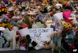 Flores pelas vítimas do ataque de 15 de Março, com um cartaz que diz "Isto não é a Nova Zelândia"