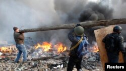 Anti-government protesters carry a roundwood as they gather in Independence Square in central Kiev February 19, 2014. Ukraine's interim prime minister said on Wednesday that protests which brought violent clashes with police on Tuesday amounted to an atte