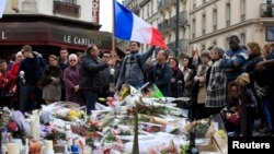 People pay tribute to victims outside Le Carillon restaurant, one of the attack sites in Paris, November 16, 2015. REUTERS/Pascal Rossignol