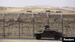 FILE - An armored Israeli military vehicle drives along Israel's border with Egypt's Sinai peninsula in January 2014. 