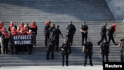 People are detained on the steps of the U.S. Capitol Building during a demonstration against planned Trump administration cuts to the U.S. refugee resettlement program, in Washington, U.S., October 15, 2019.