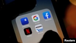 Description: The logos of mobile apps, Google, Amazon, Facebook, Apple and Netflix, are displayed on a screen in this illustration picture taken December 3, 2019. REUTERS/Regis Duvignau
