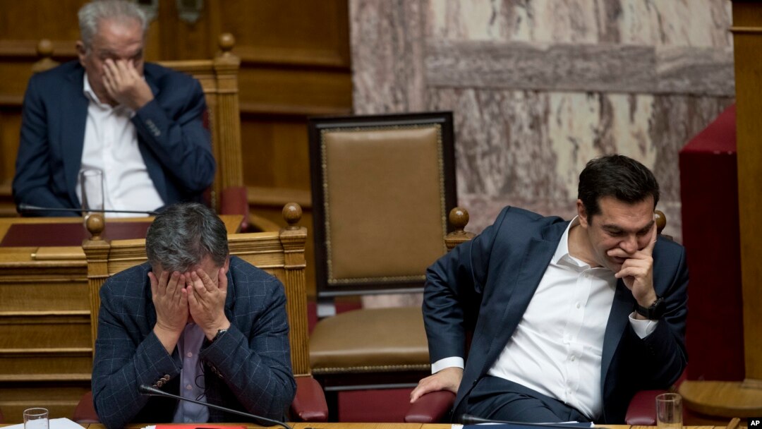 Greek Finance Minister Euclid Tsakalotos, left, and Greece's Prime Minister Alexis Tsipras react during a parliamentary session to vote more austerity measures as part of an agreement with international bailout creditors, in Athens, May 18, 2017. 