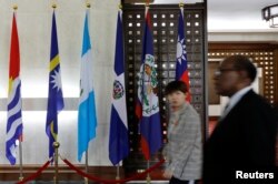 People walk next to the flag of the Dominican Republic (3rd R) inside the Taiwan Ministry of Foreign Affairs in Taipei, Taiwan, May 1, 2018.