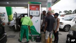 FILE: People queue at a petrol station in Lagos, Nigeria. Taken Friday, Feb. 18, 2022