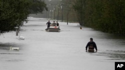 A member of the U.S. Coast Guard walks down Mill Creek Road checking houses after Tropical Storm Florence hit Newport, N.C., Sept. 15, 2018.