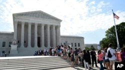 FILE - People wait in line to go into the Supreme Court in Washington.