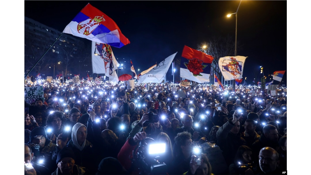 People hold up mobile phone lights during a protest over the collapse of a concrete canopy that killed 15 people more than two months ago, in Novi Sad, Serbia, Feb. 1, 2025.