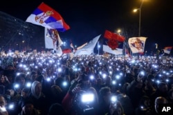 People hold up mobile phone lights during a protest over the collapse of a concrete canopy that killed 15 people more than two months ago, in Novi Sad, Serbia, Feb. 1, 2025.