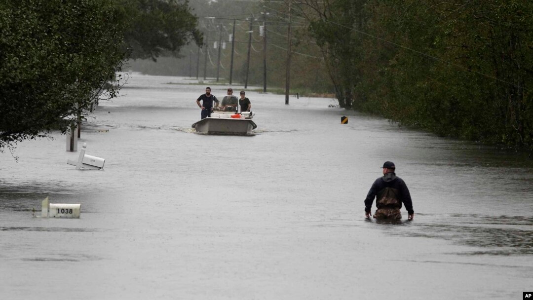 Seorang anggota Garda Pantai AS berjalan mengarungi banjir di Mill Creek Road setelah Badai Florence melanda Newport, North Carolina, 15 September 2018.