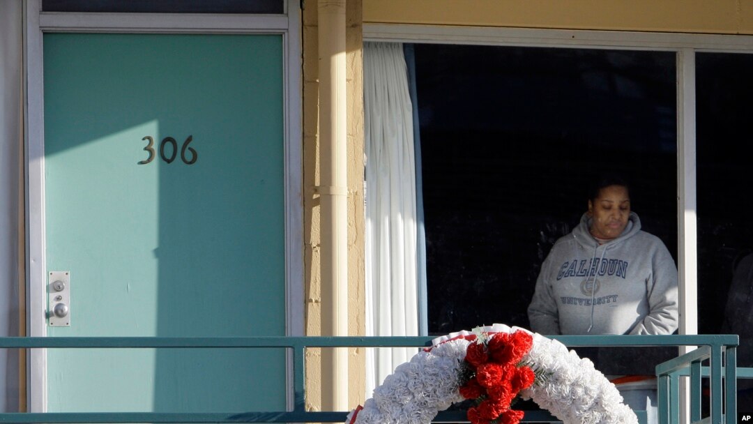 FILE - In Jan. 19, 2009, file photo, a woman looks out of a window while visiting the National Civil Rights Museum located at the Lorraine Motel in Memphis, Tenn., on the nationwide holiday honoring Martin Luther King Jr. The wreath marks the location where King was killed while standing on the balcony April 4, 1968. 