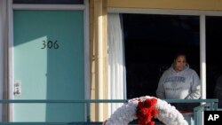 FILE - In Jan. 19, 2009, file photo, a woman looks out of a window while visiting the National Civil Rights Museum located at the Lorraine Motel in Memphis, Tenn., on the nationwide holiday honoring Martin Luther King Jr. The wreath marks the location where King was killed while standing on the balcony April 4, 1968. 