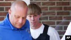 Charleston, S.C., shooting suspect Dylann Storm Roof, center, is escorted from the Shelby Police Department in Shelby, North Carolina, June 18, 2015.