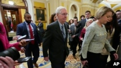 Senate Minority Leader Mitch McConnell walks past members of the media after delivering remarks on the Senate floor on Feb. 28, 2024, on Capitol Hill in Washington. McConnell says he'll step down as Senate Republican leader in November.