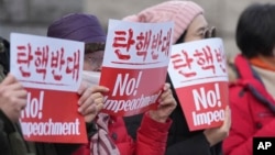 Supporters of impeached South Korean President Yoon Suk Yeol hold signs during a rally to oppose his impeachment outside the Constitutional Court in Seoul, South Korea, Jan. 14, 2025