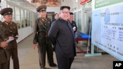 FILE - North Korean leader Kim Jong Un smiles during a visit to the Chemical Material Institute of the Academy of Defense Science in this undated photo released by North Korea's Korean Central News Agency in Pyongyang on Aug. 23, 2017.