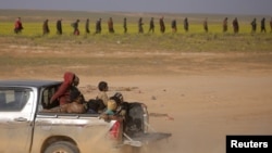 Children from the Yazidi community, who were recently freed after being captured by Islamic State fighters, ride in the back of a truck near Baghuz, Deir el-Zour province, Syria, March 6, 2019.