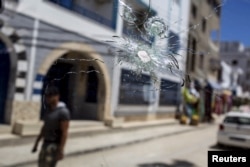 A bullet hole pockmarks the window of a car parked in the street where the gunman who attacked the Imperial Marhaba resort was killed, in Sousse, Tunisia, June 30, 2015.