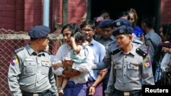 Wartawan Reuters Kyaw Soe Oo dan Wa Lone dikawal oleh polisi setibanya di pengadilan Yangon, Myanmar setelah istirahat makan siang, 14 Februari 2018. (Foto: dok).