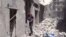This image made from video released by Qasion News Agency, a media opposition platform that relies on a network of activists on the ground, on Friday, April 29, 2016 shows people scrambling through rubble following airstrikes in Aleppo, Syria. 