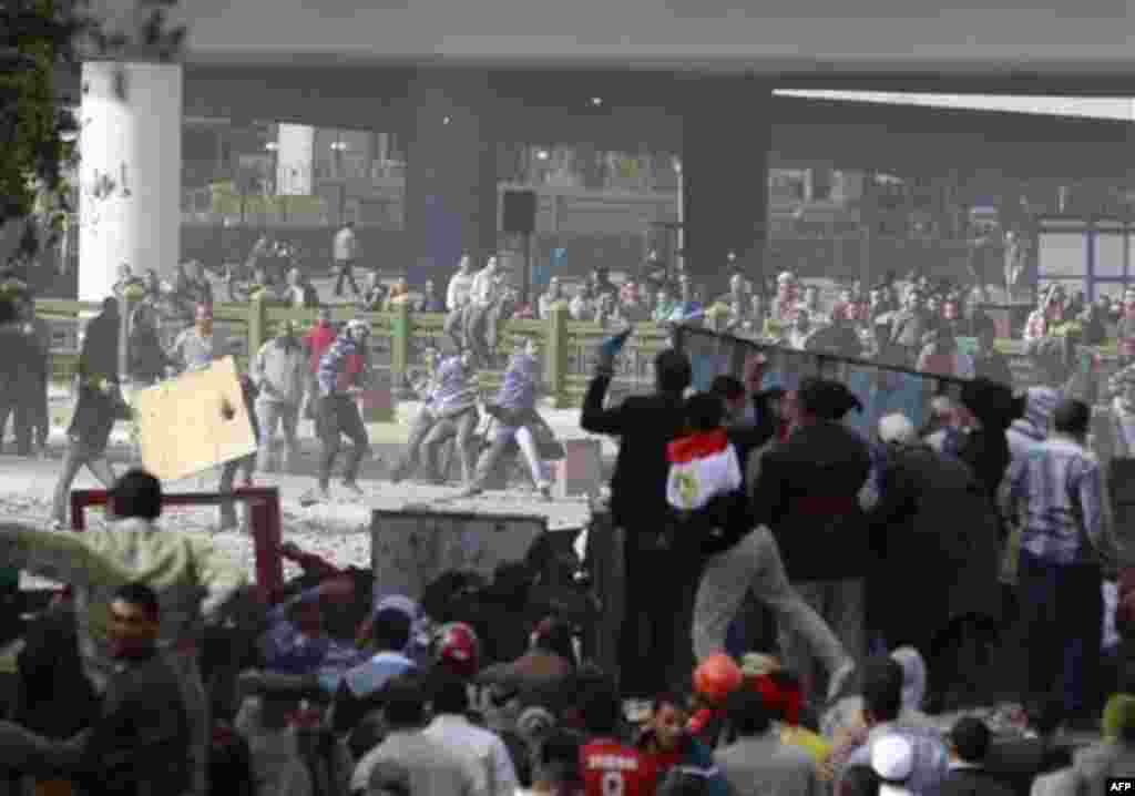 Anti government protestors, right, clash with pro government supporters near Cairo's main square, Egypt, Thursday, Feb. 3, 2011. Egypt's prime minister apologized for an attack by government supporters on protesters in a surprising show of contrition Thur