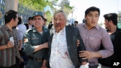 9일 폭탄 공격이 발생한 아프가니스탄 마자리 샤리프의 법원 앞에서 부상자가 부축을 받고 있다. 