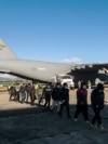 Guatemalan migrants walk from a U.S. military plane after being deported from U.S. at the Guatemalan Air Force Base in Guatemala City, Jan. 24, 2025. (Handout photo/Guatemalan Migration Institute/AFP