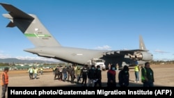 Guatemalan migrants walk from a U.S. military plane after being deported from U.S. at the Guatemalan Air Force Base in Guatemala City, Jan. 24, 2025. (Handout photo/Guatemalan Migration Institute/AFP