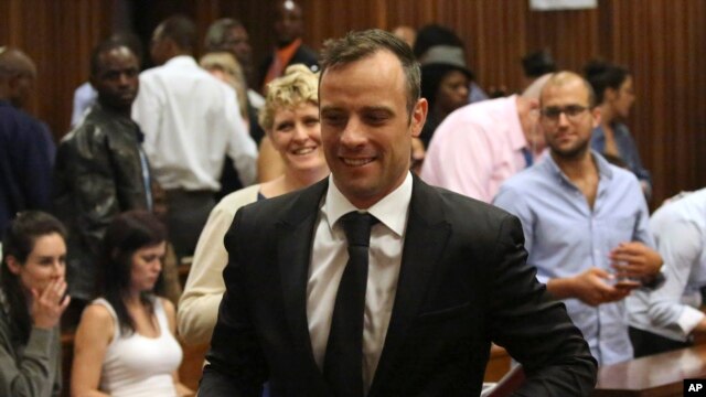 Oscar Pistorius, centro, sale de la Alta Corte en Pretoria, Sudáfrica, el martes, 8 de diciembre de 2015.