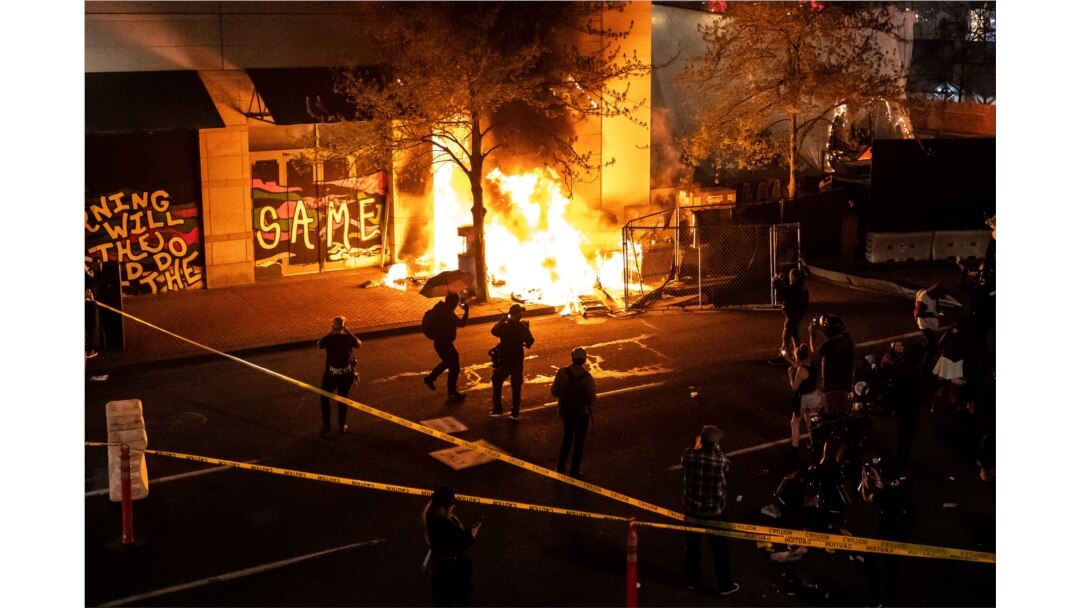 Protesters watch a structure fire set following the police shooting of a man on April 17, 2021, in Portland, Oregon.