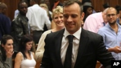 Oscar Pistorius, center, leaves a courtroom of the High Court in Pretoria, South Africa, Tuesday Dec. 8, 2015. Judge Aubrey Ledwaba granted Pistorius bail and extended his house arrest for the murder conviction of his girlfriend Reeva Steenkamp.