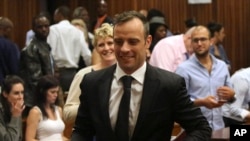 Oscar Pistorius (tengah) meninggalkan ruang pengadilan di Pretoria, Afrika Selatan, Selasa,(8/12).