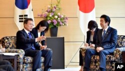 PM Jepang Shinzo Abe (kanan) menerima Presiden Korea Selatan Moon Jae-in di Tokyo, 9 Mei 2018 (foto: dok). 