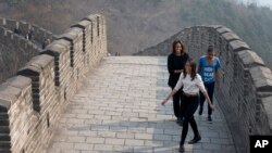 La primera dama de EE.UU., Michelle Obama, y sus hijas Malia y Sasha, caminan por la Gran Muralla China, este domingo, en Beijing.