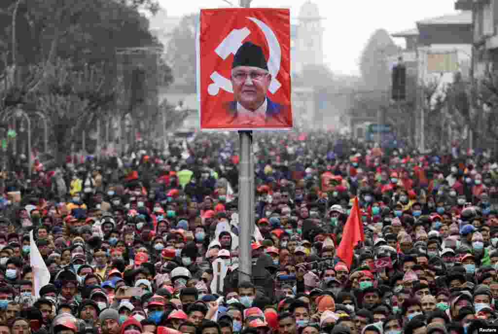 Pro-government activists gather near the portrait of Nepal's Prime Minister Khadga Prasad Sharma Oli, also known as K.P. Oli, during a mass gathering in his support, after the dissolution of parliament, in Kathmandu, Nepal.