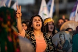 A Syrian Kurdish demonstrator shouts slogans during a protest against Turkish threats to invade the Kurdish region, in the northeastern city of Qamishli, Aug. 27, 2019.