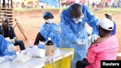 Abakora mu gisata c'amagara y'abantu bariko baratanga urucanco rwa Ebola ku mukenyezi yigeze kuba arikumwe n'uwanduye mu mihana ya Mangina mu buraruko bw'intara ya Kivu, RDC, itariki 18/08/2018.