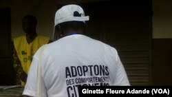 Une femme porte un t-shirt appelant à avoir un comportement citoyen lors de cette journée électorale, le 6 mars 2016 à Cotonou, Bénin. (VOA/Ginette Fleure Adande) 