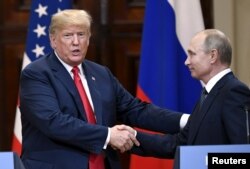 FILE - U.S. President Donald Trump and Russia's President Vladimir Putin shake hands after their joint news conference in the Presidential Palace in Helsinki, Finland, July 16, 2018.