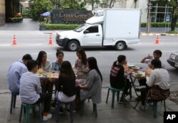 In this April 7, 2017 photo, people have their lunch at a street food shop on Thonglor road in Bangkok, Thailand. Officials see street food as an illegal nuisance and have warned hawkers in Thonglor to clear out by April 17.