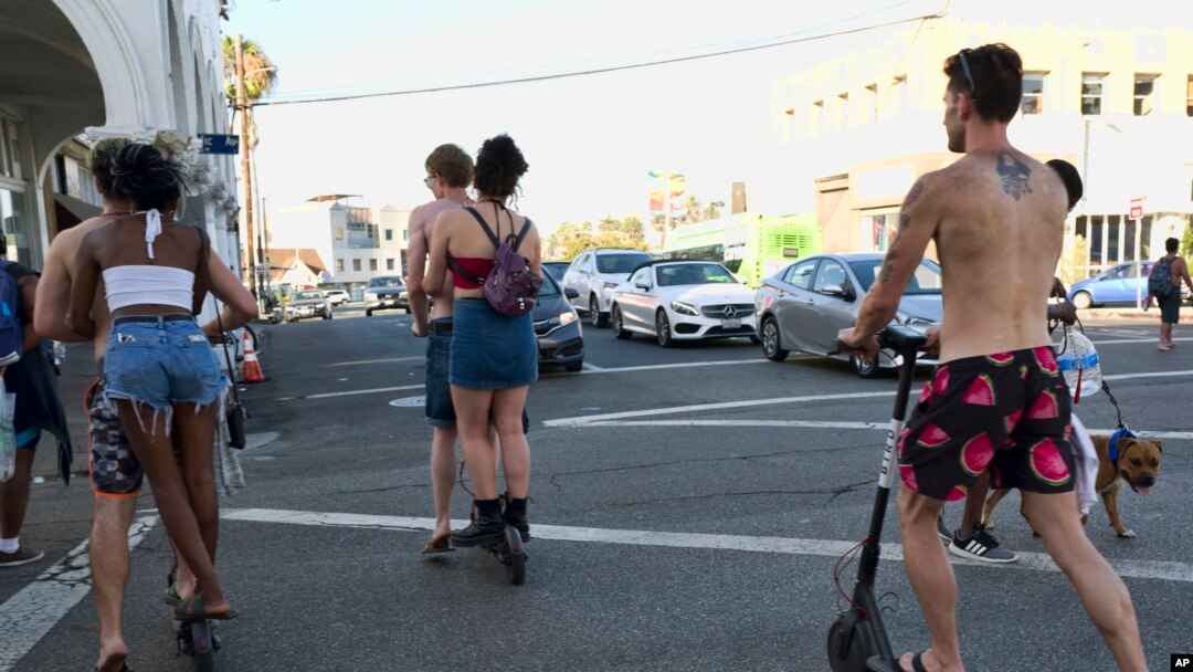 Ljudi na skuterima na ulici u Venis biču, u Los Anđelesu (Foto: AP)