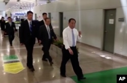 In this image made from video, Kim Yong Chol, in white, a former military intelligence chief who is now Kim Jong Un's top official on inter-Korean relations, walks upon arrival at Beijing airport in Beijing, May 29, 2018.