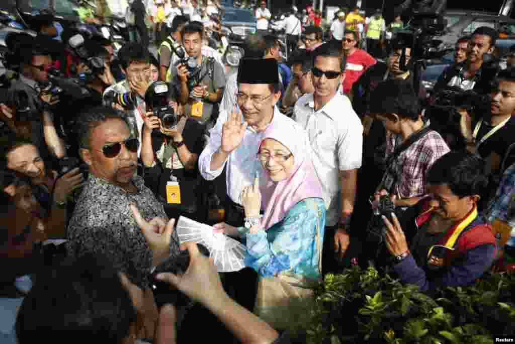 Opposition leader Anwar Ibrahim leaves a polling station with his wife Wan Azizah Wan Ismail after casting their votes during the general elections in Permatang Pauh, Malaysia, May 5, 2013. 