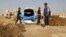 This frame grab from a video provided on Nov. 22, 2018, shows Syrian workers of a Raqqa group carrying human remains at the site of a mass grave believed to contain the bodies of civilians and Islamic State militants, in Raqqa. 